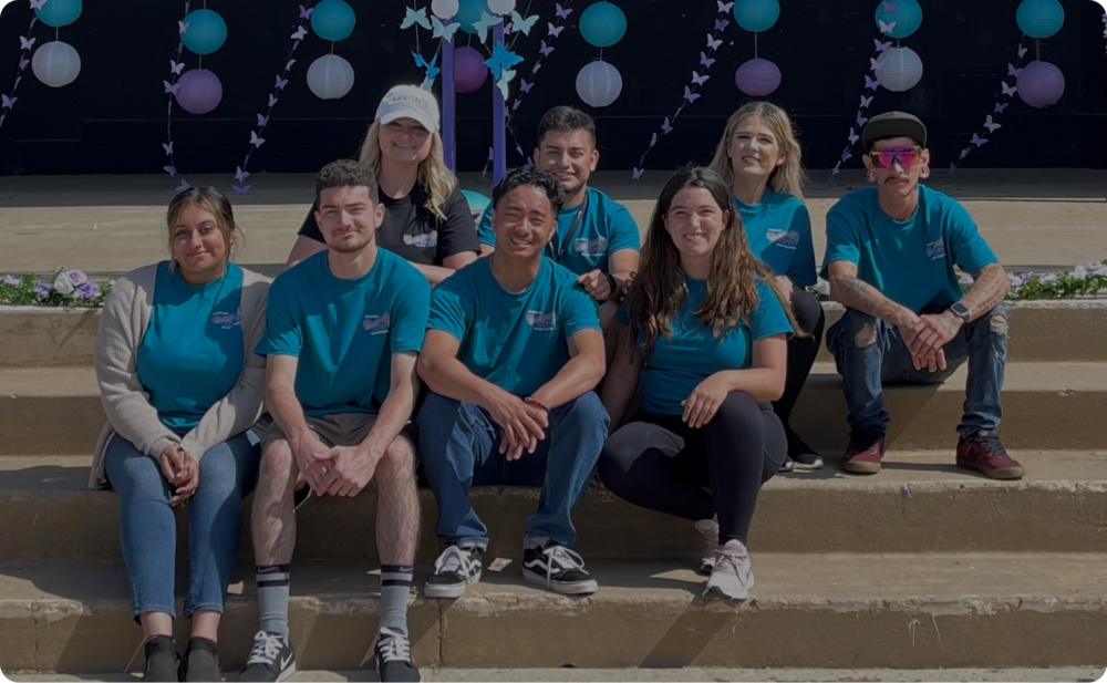A group of volunteers sitting on stairs.